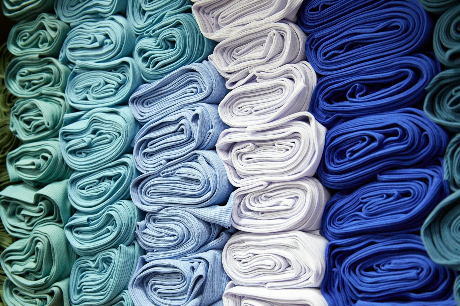 Rolled fabrics in teal, pale blue, white and royal blue