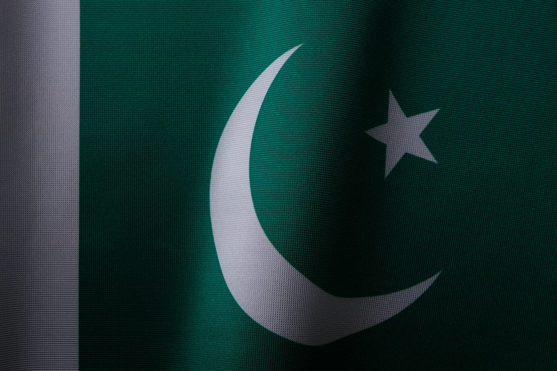 Close up of the green and white flag of Pakistan with its crescent and star