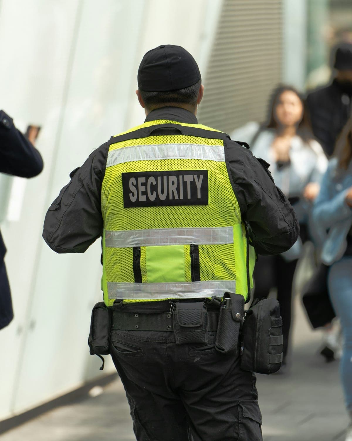 Security officer in a high visibility vest walking through a crowd