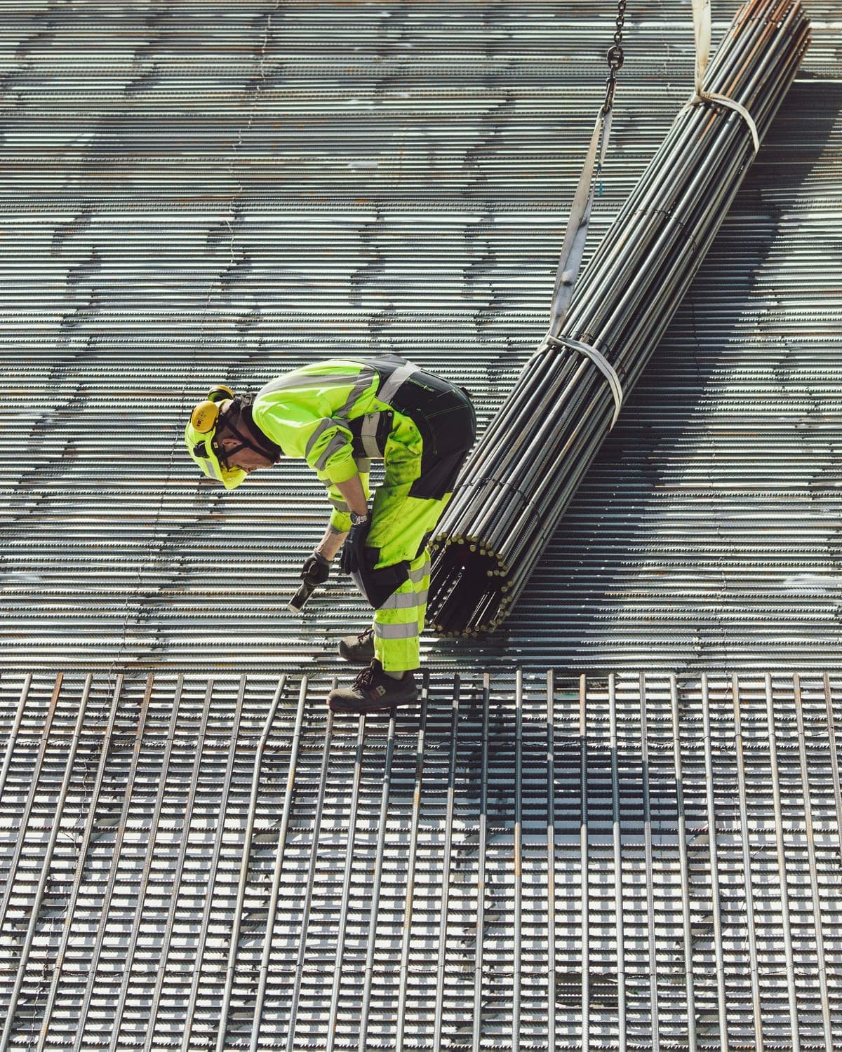 Construction worker in high visibility clothing working on a steel grate