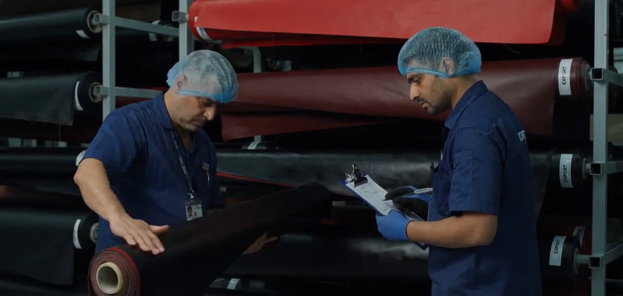Two of our team checking a fabric roll against the order sheet in the fabric store